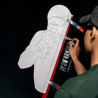 Person spray painting a white target with red accents on a black background
