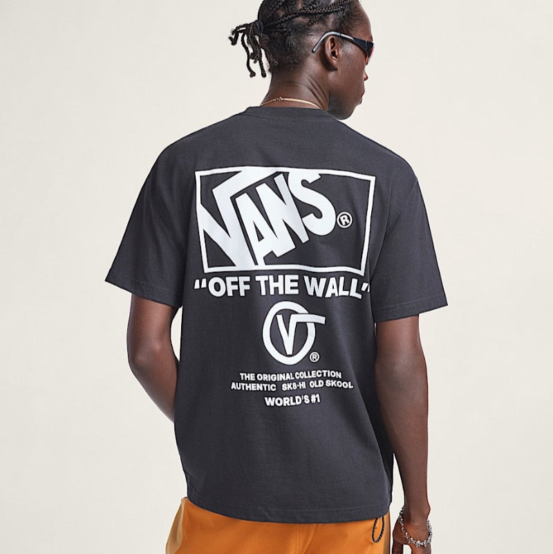 Person wearing a black Vans t-shirt with branding on the back against a plain background