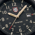 Macro close-up of the Luminox Atacama Field 1970 watch face, showing the textured black dial, sand-colored numerals, red arrow date indicator, and dual-scale hour markings, emphasizing high-contrast readability for tactical and outdoor field use.