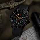 Lifestyle flat lay of the Luminox RECON Point Man 8820 Series Heritage watch arranged with tactical gear, emphasizing its CARBONOX case, navigation bezel, constant-glow illumination, and outdoor mission features designed for land navigation, field readiness, and rugged performance.