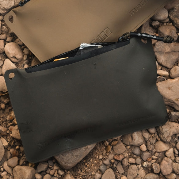 Magpul DAKA Pouch Small OD Green organizing small tools and parts sitting outside highlighting durable polymer waterproof design