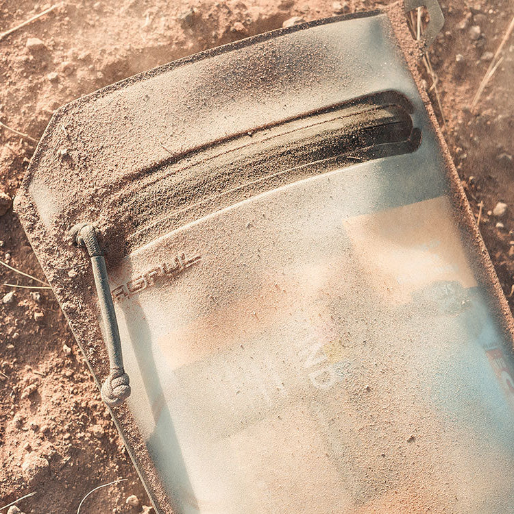 Magpul DAKA Volume Pouch Flat Dark Earth placed in dirt outdoors highlighting durable waterproof construction