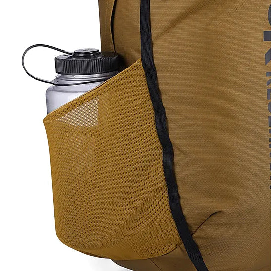 Detail view of the Outdoor Research Adrenaline Day Pack 30L in coyote, showing side mesh water bottle pocket designed for quick-access hydration during alpine, hiking, or tactical missions.