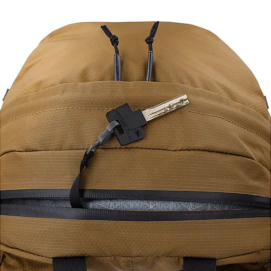 Detail view of the Outdoor Research Adrenaline Day Pack 30L in coyote, highlighting the interior key clip and storage pocket for secure organization of essentials on alpine missions, hikes, or tactical carry.