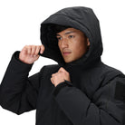 Detail view of the Outdoor Research Allies Colossus II Parka showing a model pulling the insulated hood up and zipping the waterproof YKK® AquaGuard front closure, highlighting extreme cold weather parka design for Arctic missions, military use, and survival in subzero conditions.