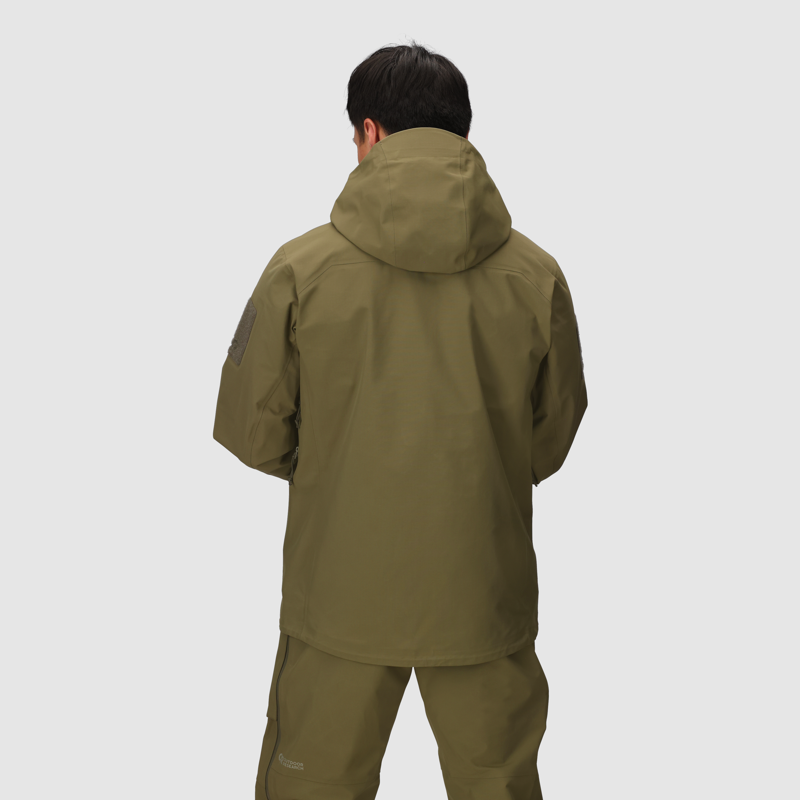 Back view of the Outdoor Research Allies Mountain II Jacket in Ranger Green showing the durable Cordura ripstop shell, helmet compatible hood, articulated combat fit, and full-coverage waterproof design built for military, law enforcement, and alpine professionals operating in extreme weather conditions.