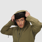 Close up of the Outdoor Research Allies Mountain II Jacket in Ranger Green showing the helmet compatible hood being pulled up, highlighting the adjustable hood system, AscentShell waterproof construction, and Cordura ripstop durability built for military, law enforcement, and alpine professionals operating in extreme weather.