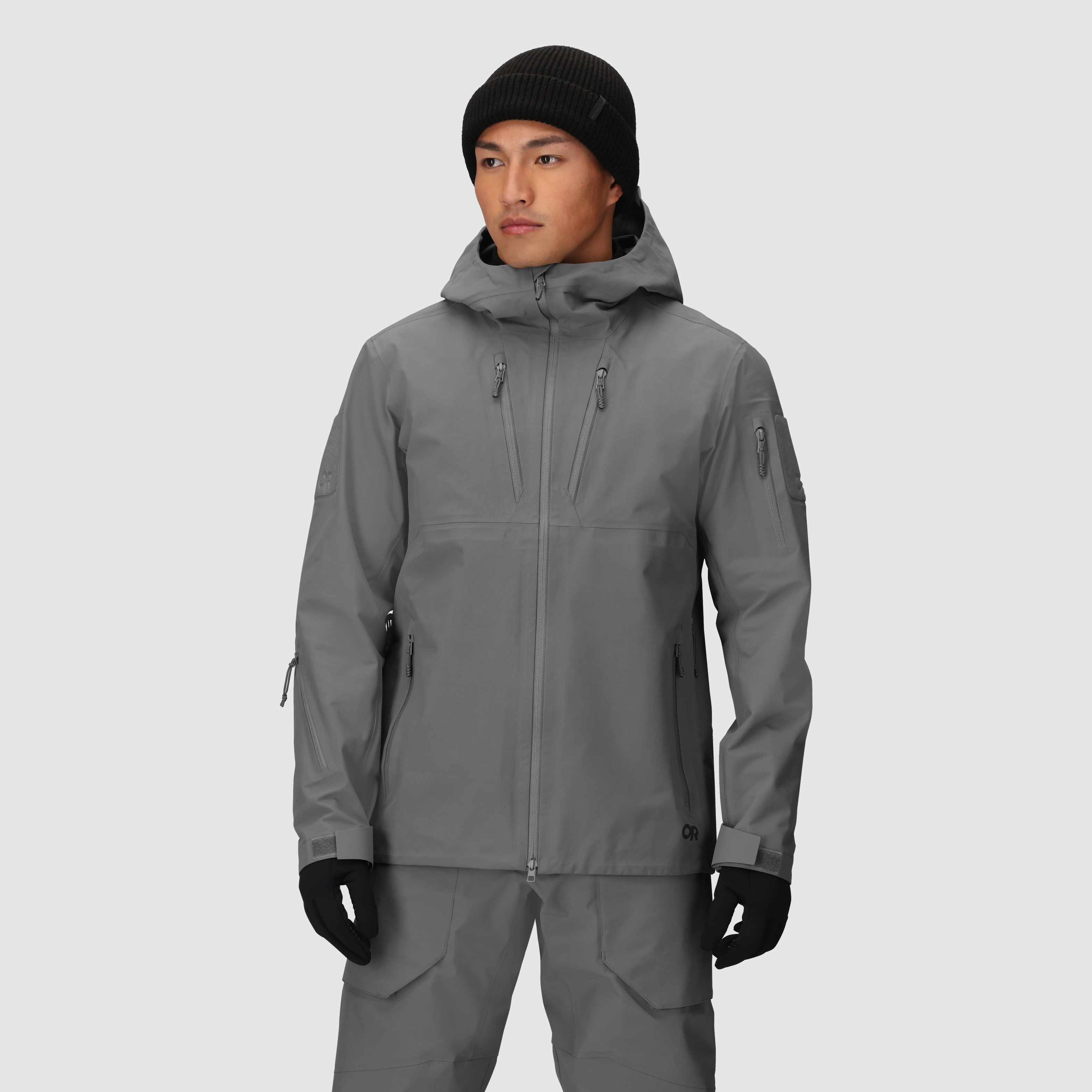 On-body view of the Outdoor Research Allies Mountain II Jacket in Wolf Grey showing the AscentShell waterproof construction, Cordura ripstop durability, helmet compatible hood, and articulated combat fit designed for military, law enforcement, and alpine professionals operating in extreme weather and rugged terrain.
