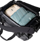 Outdoor Research CarryOut Duffel 40L in Black shown open and packed with contents visible | Rugged PU coated 420D ripstop nylon duffel with 40 liter capacity dirty clean gear divider internal zip pocket and compression straps — best tactical duffel for organized travel and outdoor missions