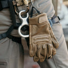 Outdoor Research Ironsight II FR Gloves in Coyote clipped to operator harness during field operations, flame resistant Nomex and Kevlar tactical duty gloves staged on combat gear for military missions, range training, and law enforcement duty readiness