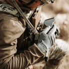Operator wearing Outdoor Research Ironsight II FR Gloves in Wolf Grey during tactical training, flame resistant Nomex and Kevlar duty gloves integrated into full combat gear setup for military operations, range use, and law enforcement field applications