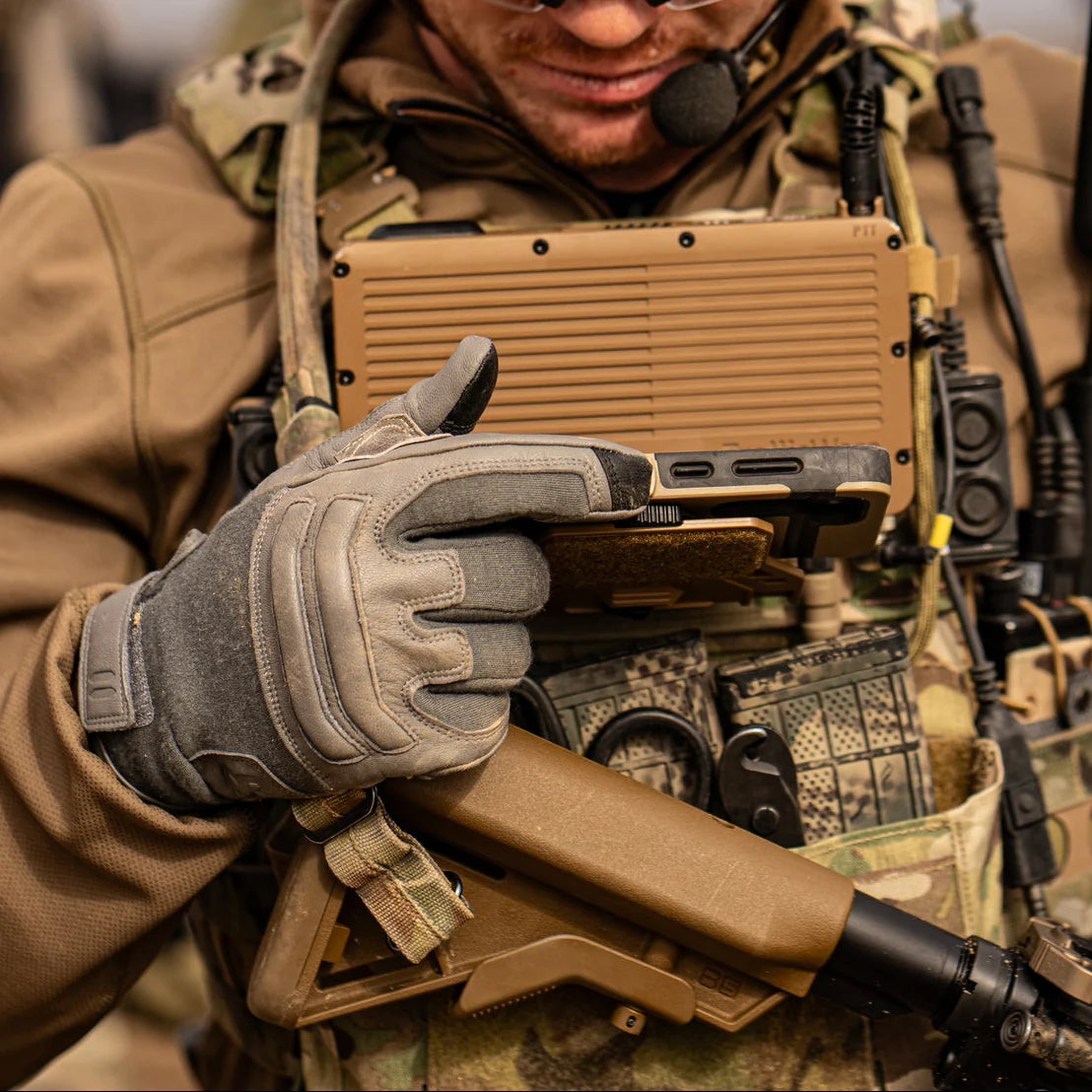 Operator wearing Outdoor Research Ironsight II FR Gloves in Wolf Grey during field operations, flame resistant Nomex and Kevlar tactical duty gloves integrated into full combat gear setup for military missions, range training, and law enforcement duty applications