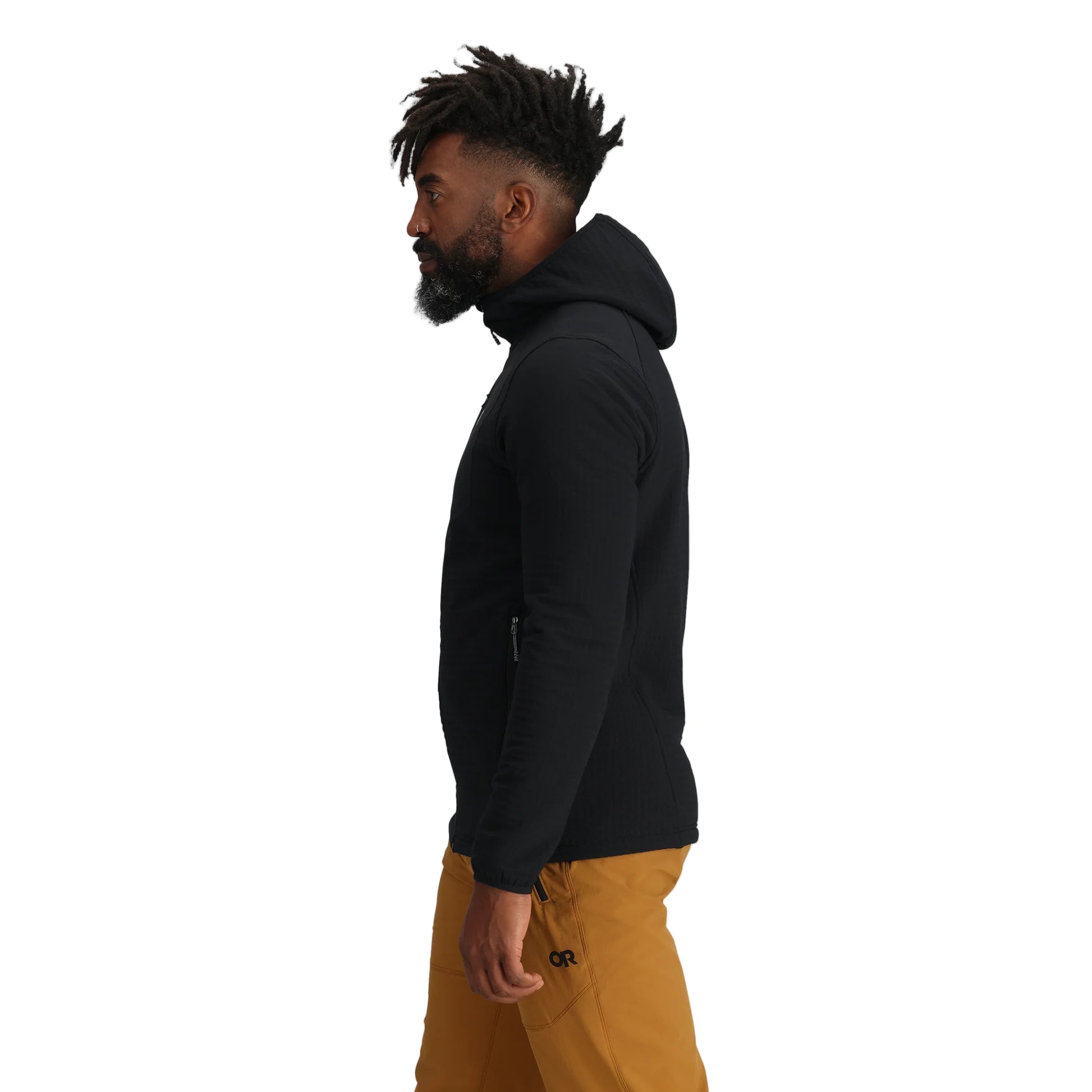 Side view of the Outdoor Research Vigor Plus Fleece Hoodie in black, shown on a model to highlight the athletic fit, stretch side panels, and ergonomic hood design built for layering and active cold-weather pursuits.