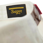 Close-up of a white shirt with a black label featuring the brand 'Seager' in yellow text.