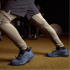 Lifestyle photo of the Salomon Trail Running Shoe in Black being worn during indoor gym training, showing the supportive midsole and slip-resistant outsole in action. Designed for tactical athletes, law enforcement, and EMS professionals who train hard and move fast. Combines lightweight comfort, durability, and grip for high-intensity workouts, rucking, and conditioning sessions.