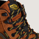 Brown boot with black and yellow laces and Vans Off The Wall logo on a beige background