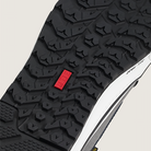 Close-up of a black shoe sole with a red label on a light gray background