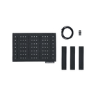 Black studded panel with four black strap-like pieces, a coiled black cable, and a small metal connector, arranged on a plain white background. A small label near the bottom of the panel reads 'SPIRITUS SYSTEMS'.