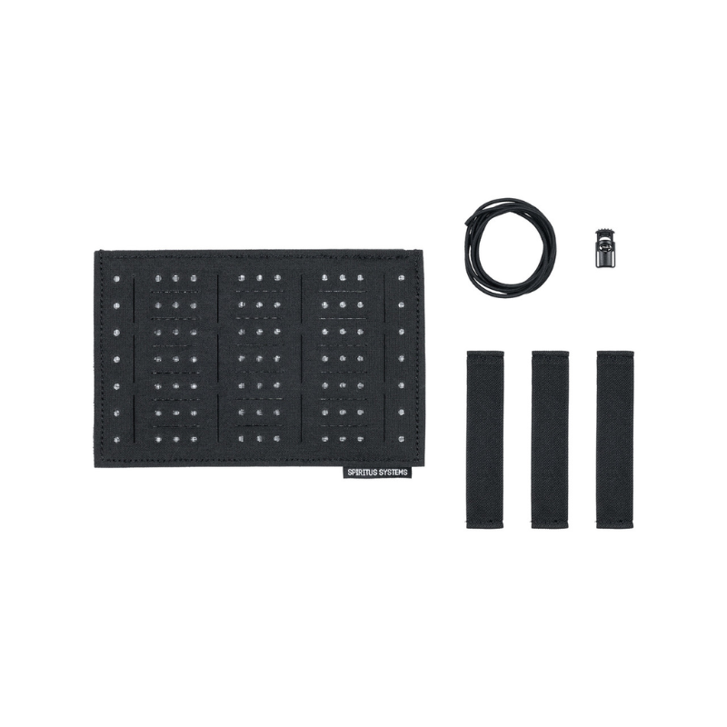 Black studded panel with four black strap-like pieces, a coiled black cable, and a small metal connector, arranged on a plain white background. A small label near the bottom of the panel reads 'SPIRITUS SYSTEMS'.