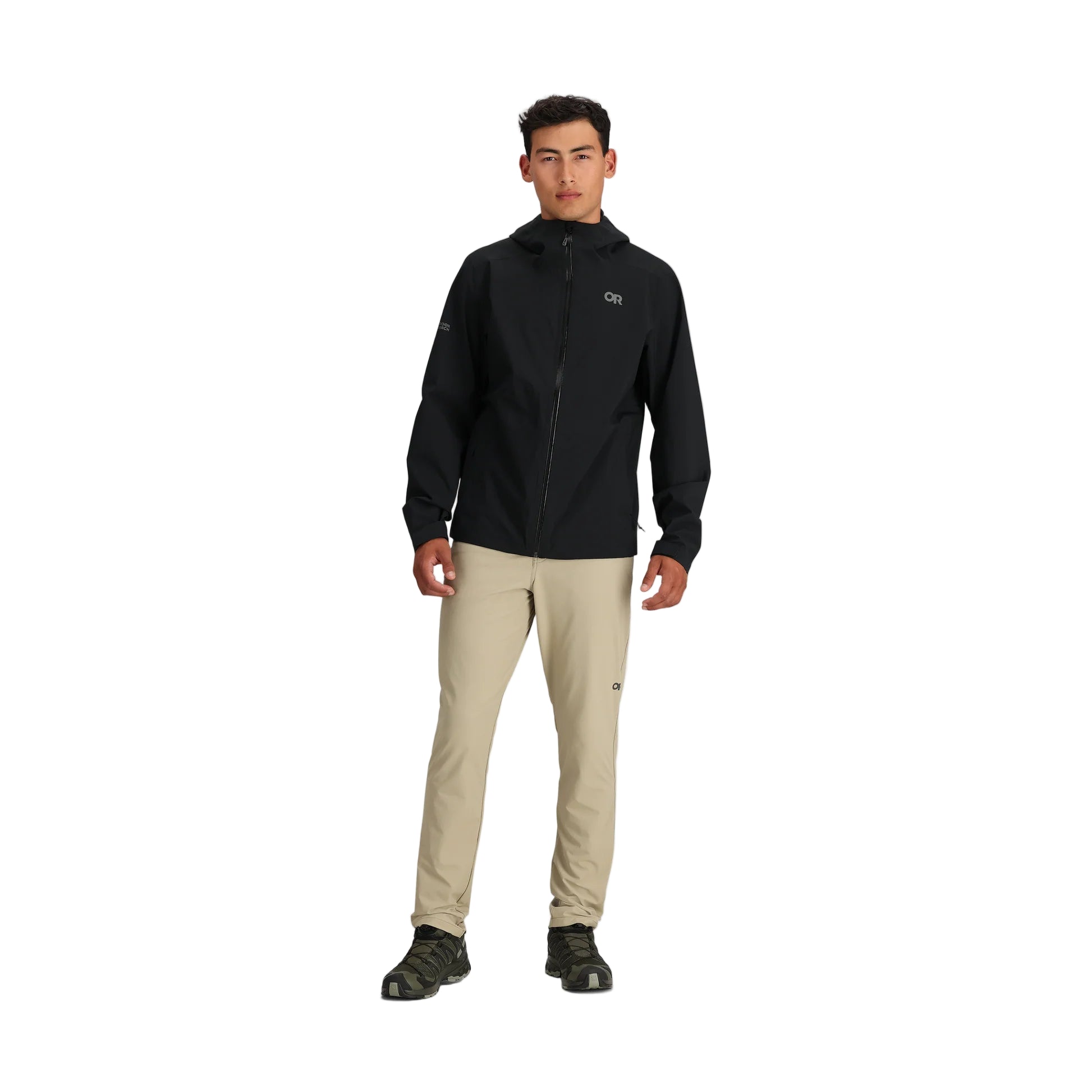 Full body view of the Outdoor Research Stratoburst Rain Jacket in black, worn outdoors to show tactical fit, full-length weather coverage, and lightweight mobility