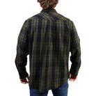 A man viewed from the back wearing a dark green and black plaid flannel shirt with blue jeans, set against a plain white background.
