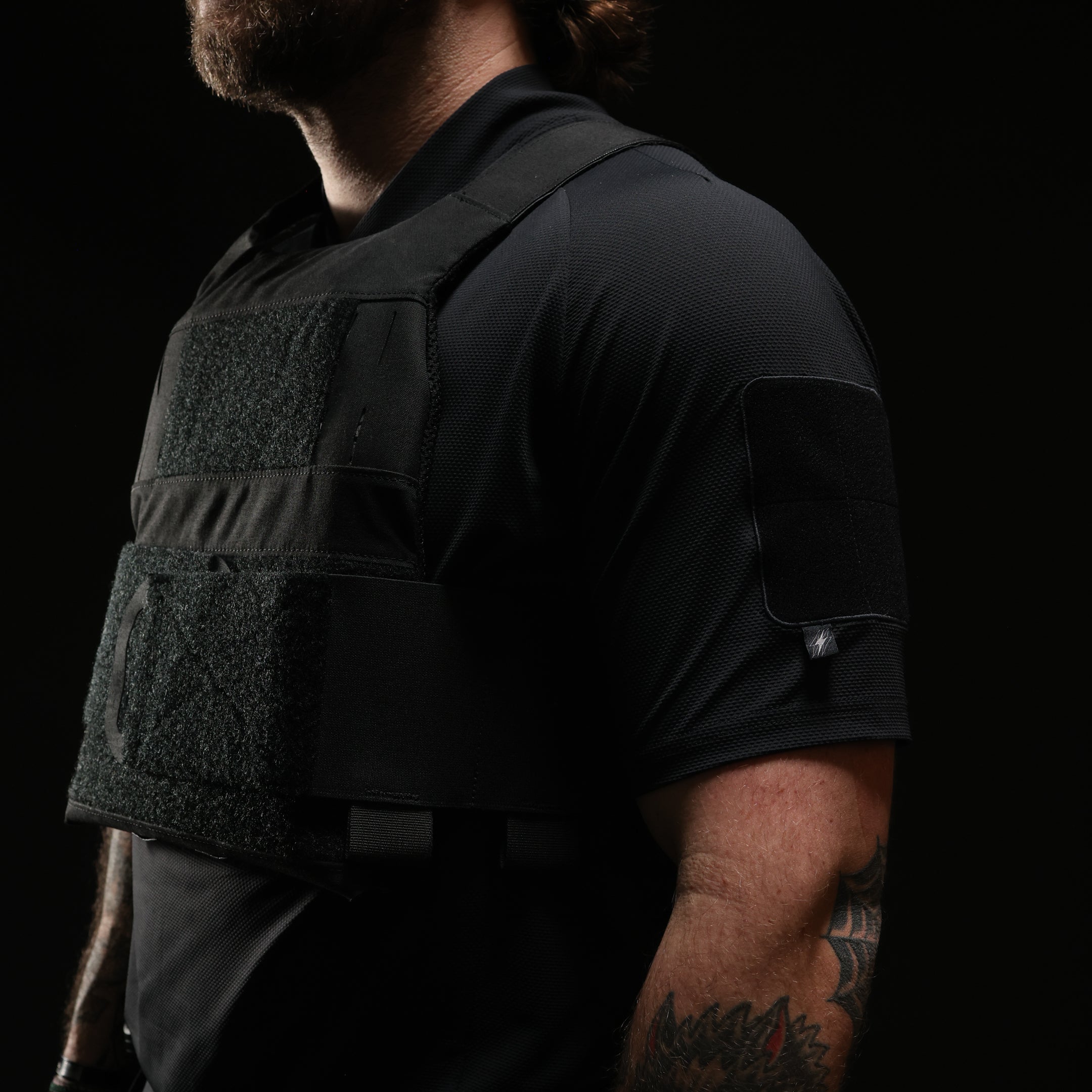 Operator wearing TD OSS Top Short Sleeve in Black under plate carrier, lightweight tactical range shirt and combat base layer designed for hot weather training, shooter drills, and professional duty use in full kit configurations