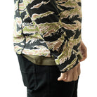 Close up of TD Outdoor Tiger Shark Sun Shirt in Golden Tiger camo showing sleeve construction, tonal flatlock stitching, and hidden thumb loop integration on lightweight UPF 50 tactical sun hoodie built for glove compatible outdoor performance