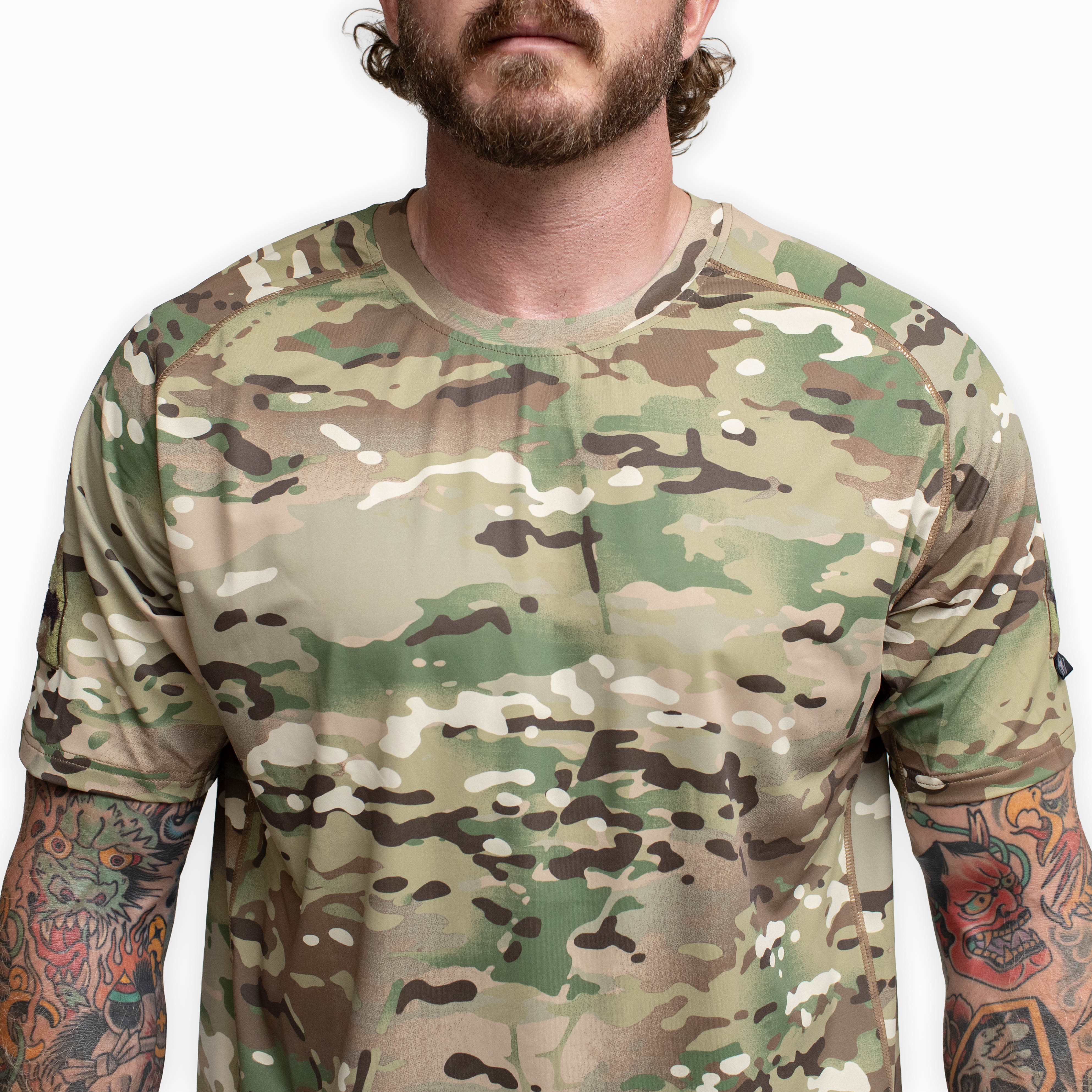 Close up of the front chest area on the TD Shooter Shirt MultiCam short sleeve showing the tonal screen printed branding, smooth self fabric collar, and moisture wicking 4 way stretch material designed for comfort under kit and reliable performance on the range. Available through Tactical Distributors for tactical users across the United States.