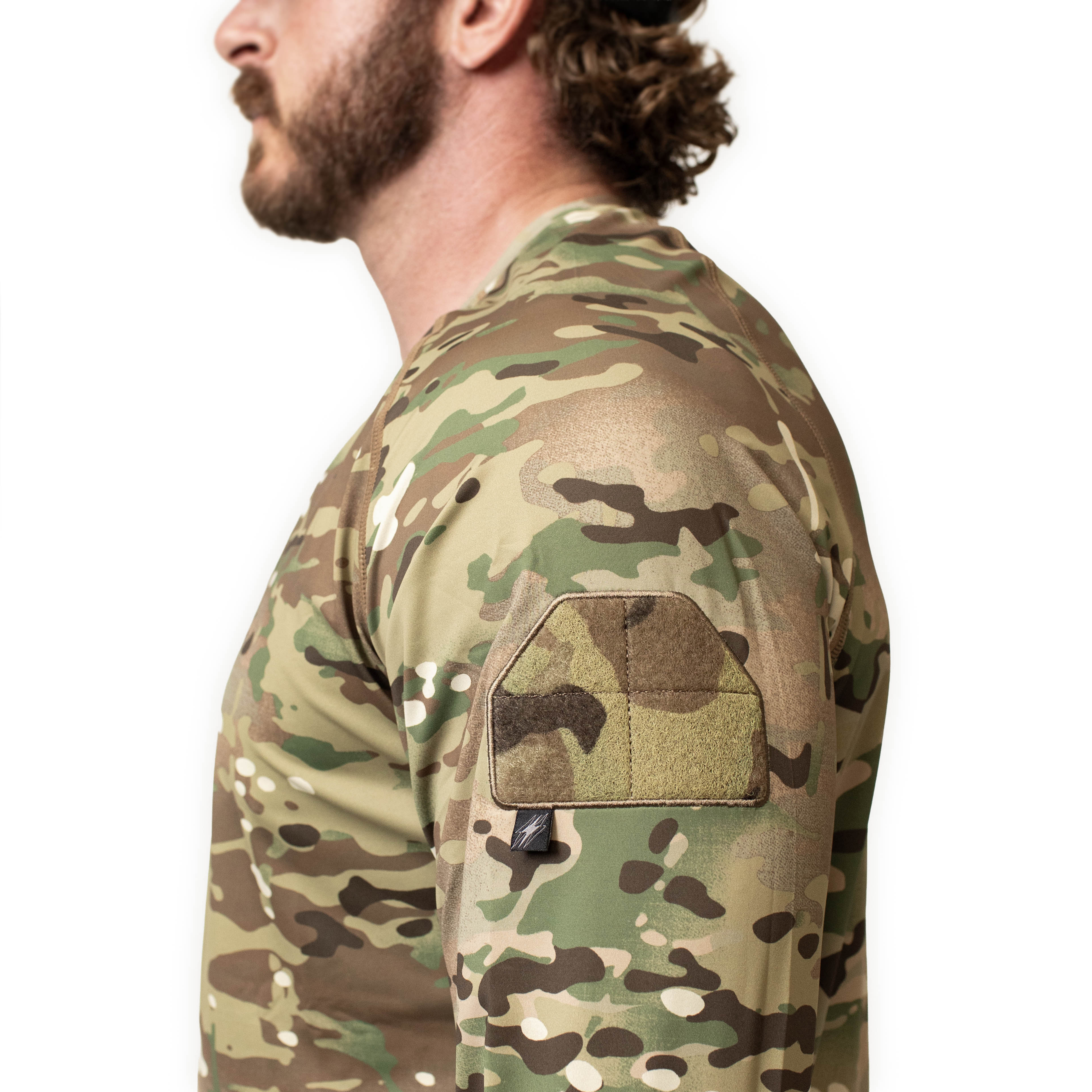 Close up detail of the TD Shooter Shirt MultiCam long sleeve showing the raglan sleeve construction, tonal flatlock stitching, and moisture wicking 4 way stretch fabric designed for durability and comfort under tactical gear. Available from Tactical Distributors in Virginia Beach for shooters and professionals across the United States.