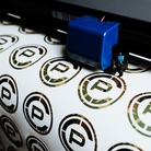 Close-up of TD x Crye Precision M81 Woodland stickers in production, highlighting the locally printed collaboration artwork and limited-edition manufacturing process.