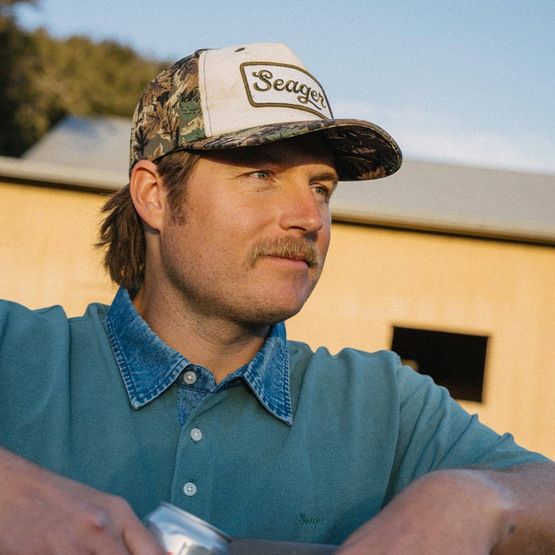 Man wearing a Seager cap and blue shirt outdoors