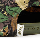 Camouflage cap with a visible brand label on a white background