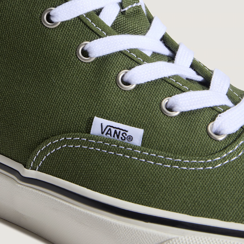 Green Vans sneaker with white laces on a light background