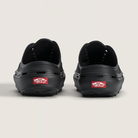 Black shoes with a red Vans label on the sole against a light gray background