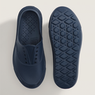 Navy blue slip-on shoe with textured sole on a light gray background