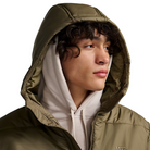 Close view of the Vans Hillgate Puffer Jacket in Bungee Cord brown with the hood up showing the insulated 10 oz poly fill construction and recycled polyester shell designed for cold weather protection.