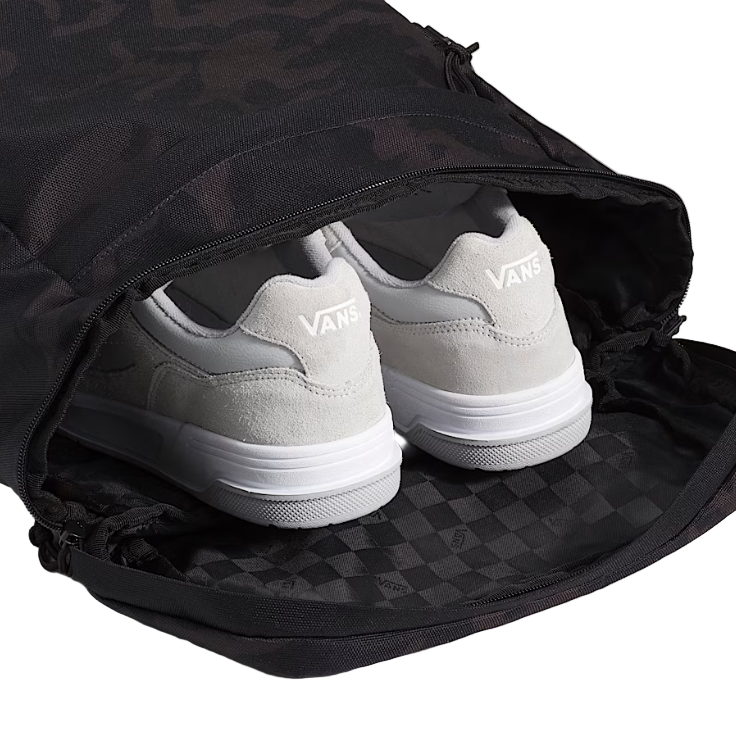 Vans Omit Backpack shown open with shoes inside the main compartment highlighting the spacious Cordura 28 liter interior, mesh pockets, and organized storage designed for travel, gym days, and daily carry.