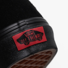 Close-up of the Vans Sk8-Hi in black on black suede showing the iconic “Off The Wall” heel tag. Classic high-top skate shoe with padded collar, reinforced heel, and durable waffle outsole for grip and style.