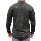 Product shot of the Velocity Systems BOSS Rugby Long Sleeve Combat Shirt in MultiCam Black, a professional tactical base layer engineered for law enforcement, military operators, and range instructors. Made in the USA from 4-way stretch nylon-spandex, this long sleeve combat top delivers moisture-wicking performance, UV protection, and Odorexx™ antimicrobial control for all-day wear. Featuring dual sleeve pockets with loop panels and a low-profile collar for carrier compatibility, the BOSS Rugby MultiCam Bl