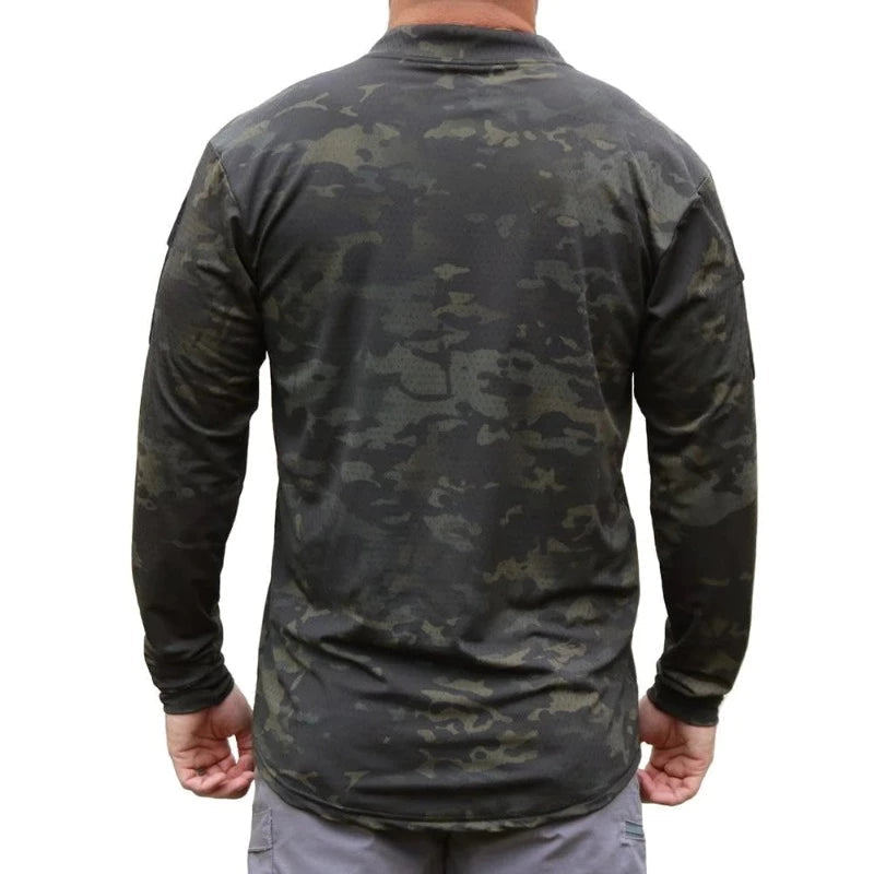 Product shot of the Velocity Systems BOSS Rugby Long Sleeve Combat Shirt in MultiCam Black, a professional tactical base layer engineered for law enforcement, military operators, and range instructors. Made in the USA from 4-way stretch nylon-spandex, this long sleeve combat top delivers moisture-wicking performance, UV protection, and Odorexx™ antimicrobial control for all-day wear. Featuring dual sleeve pockets with loop panels and a low-profile collar for carrier compatibility, the BOSS Rugby MultiCam Bl