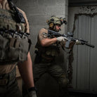 Velocity Systems BOSS Rugby Short Sleeve Combat Shirt worn in a tactical combat environment with full kit. USA-made operator base layer built for military, range, and field missions with 4-way stretch, moisture-wicking fabric, and UV protection.