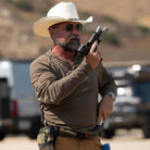 Lifestyle image of the Velocity Systems BOSS Rugby Long Sleeve Combat Shirt worn during tactical operations with a firearm, showcasing its 4-way stretch nylon-spandex construction, moisture-wicking performance, and low-profile collar built for compatibility with body armor and slings. Designed for law enforcement, military, and security professionals, this long sleeve range shirt delivers elite mobility, durability, and comfort for dynamic movement and mission-critical performance in the field. Made in the 