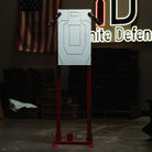 Target practice stand with a target on a stand in a room with an American flag and 'Infinite Defense' sign.