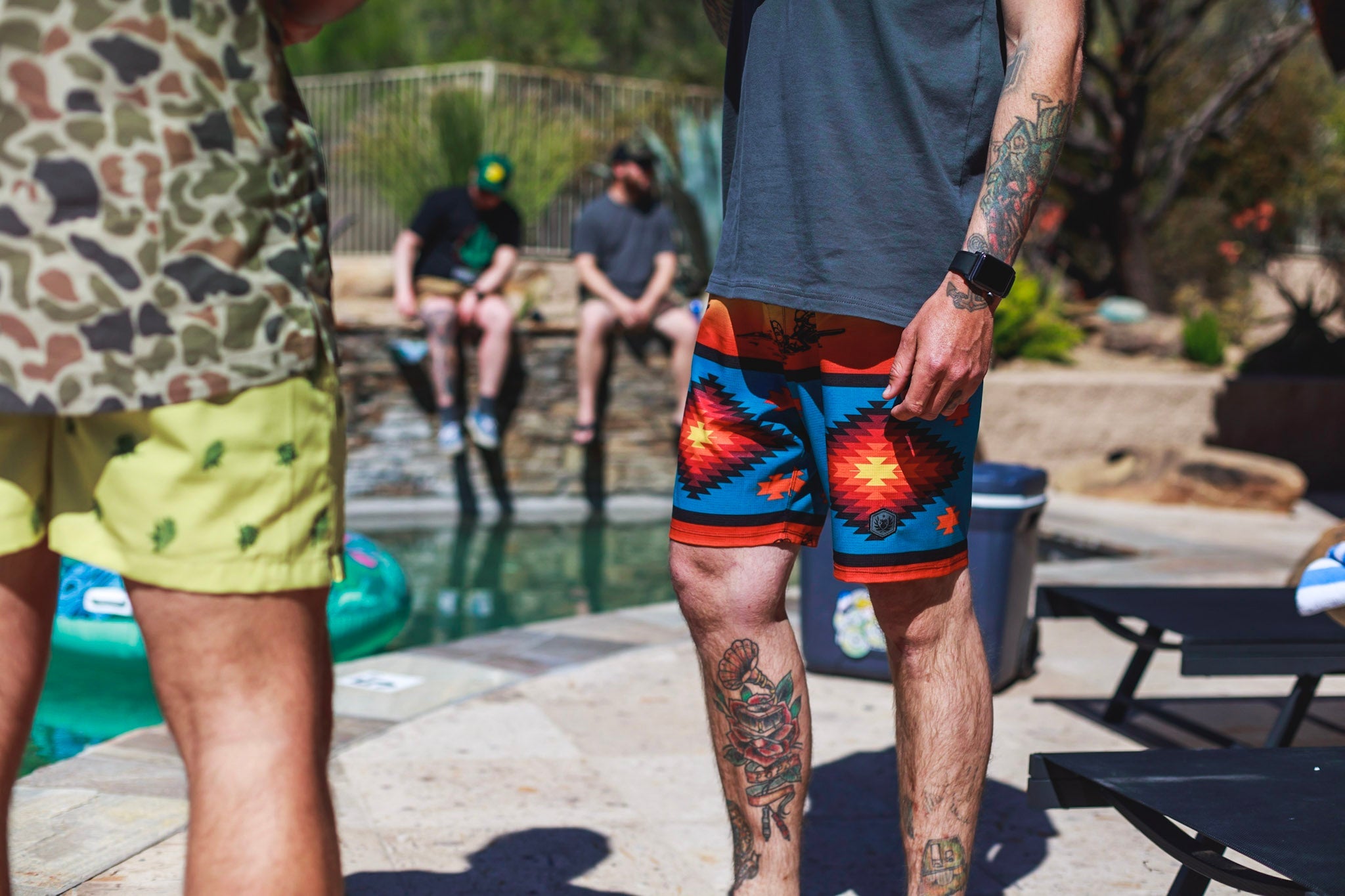men wearing board shorts along pool