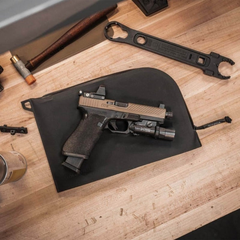 Magpul DAKA Single Pistol Case Black sitting on workbench beside handgun showing water resistant soft case used for range day storage and firearm transport