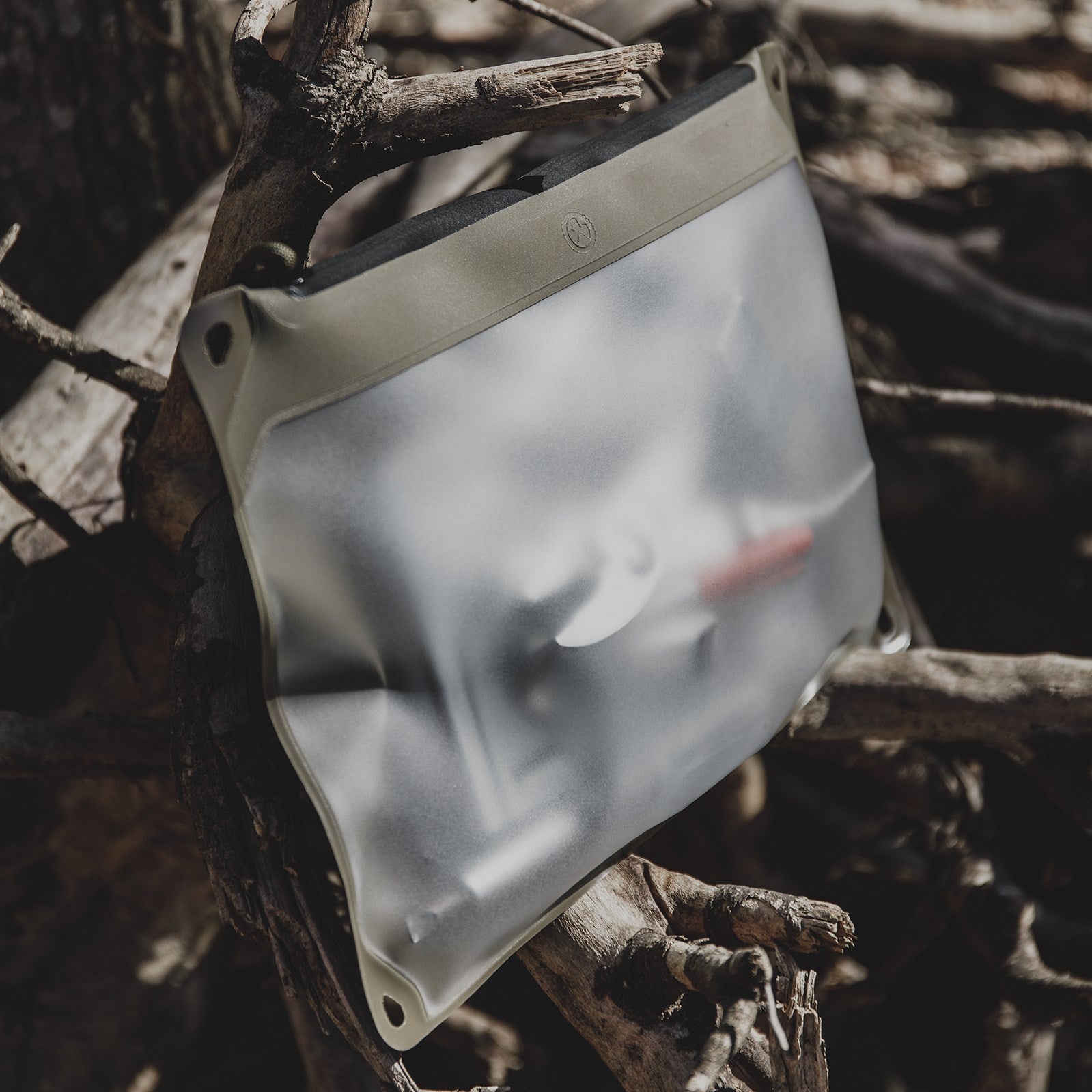 Magpul DAKA Window Pouch Large Flat Dark Earth placed in dirt and wet conditions highlighting waterproof RF welded seam construction